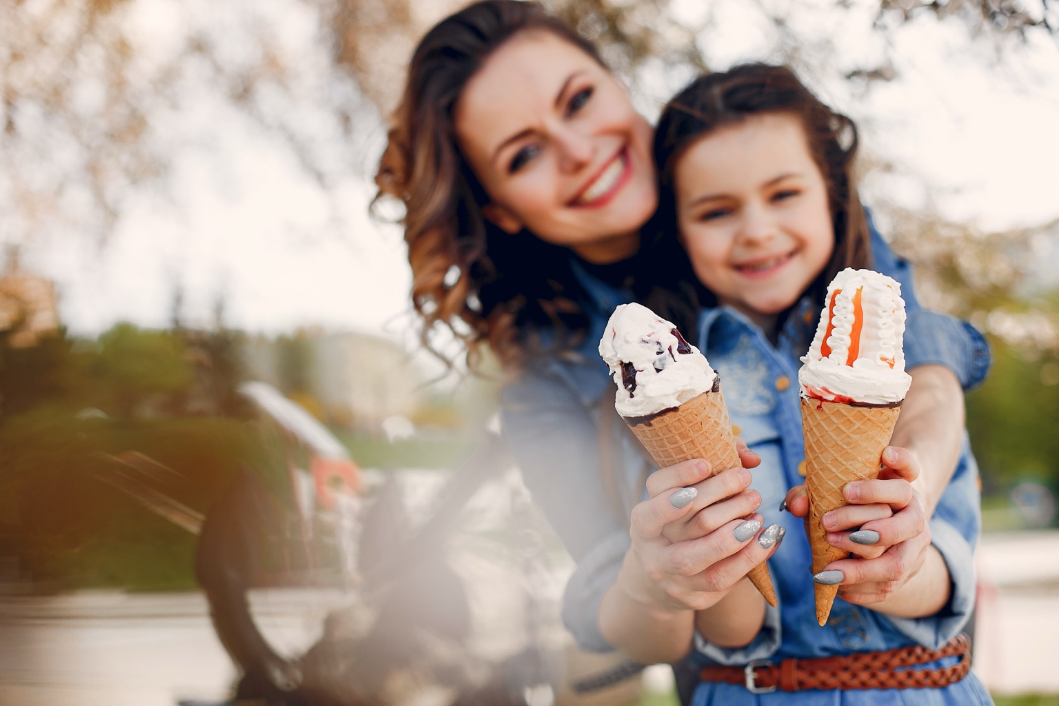 A parent and child sharing ice cream in the park